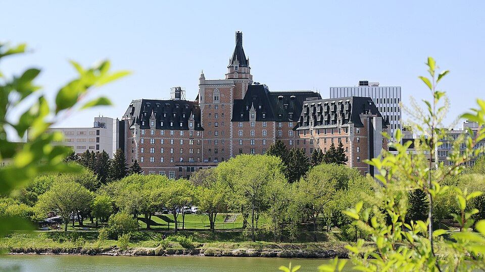 The Bessborough across the river in Saskatoon, framed by spring greenery.