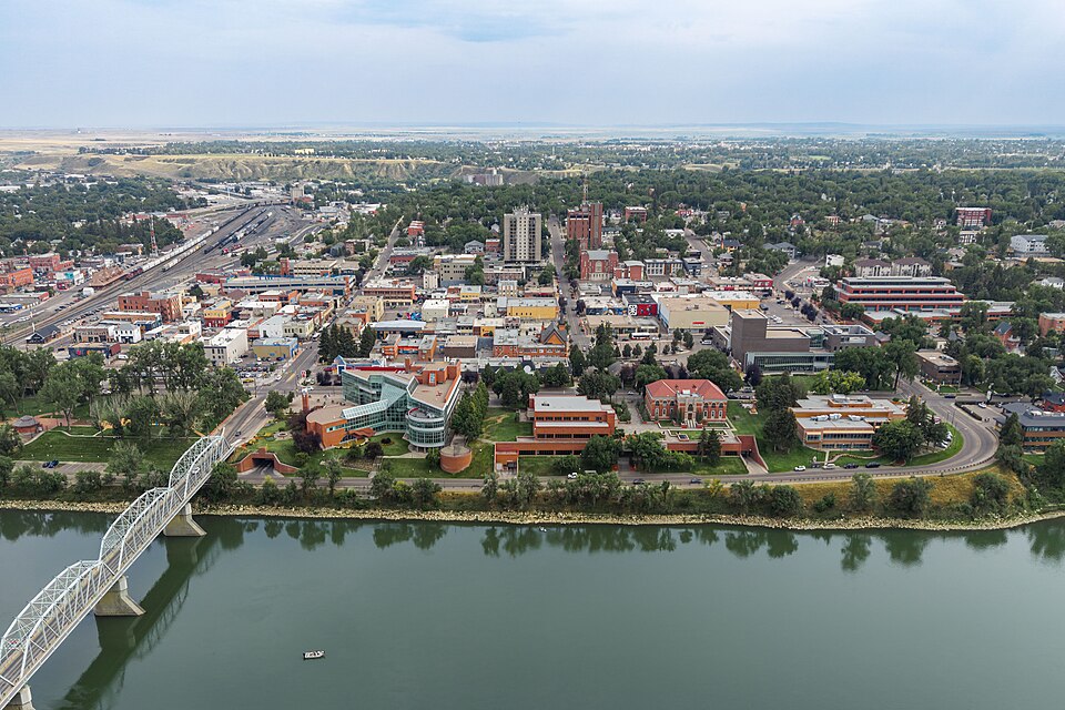Downtown Medicine Hat, city hall, bridge and green riverbanks seen from above.